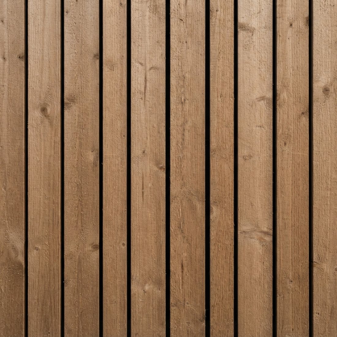 Vertical timber cladding in close detail, narrow boards with fine shadow gaps between them.